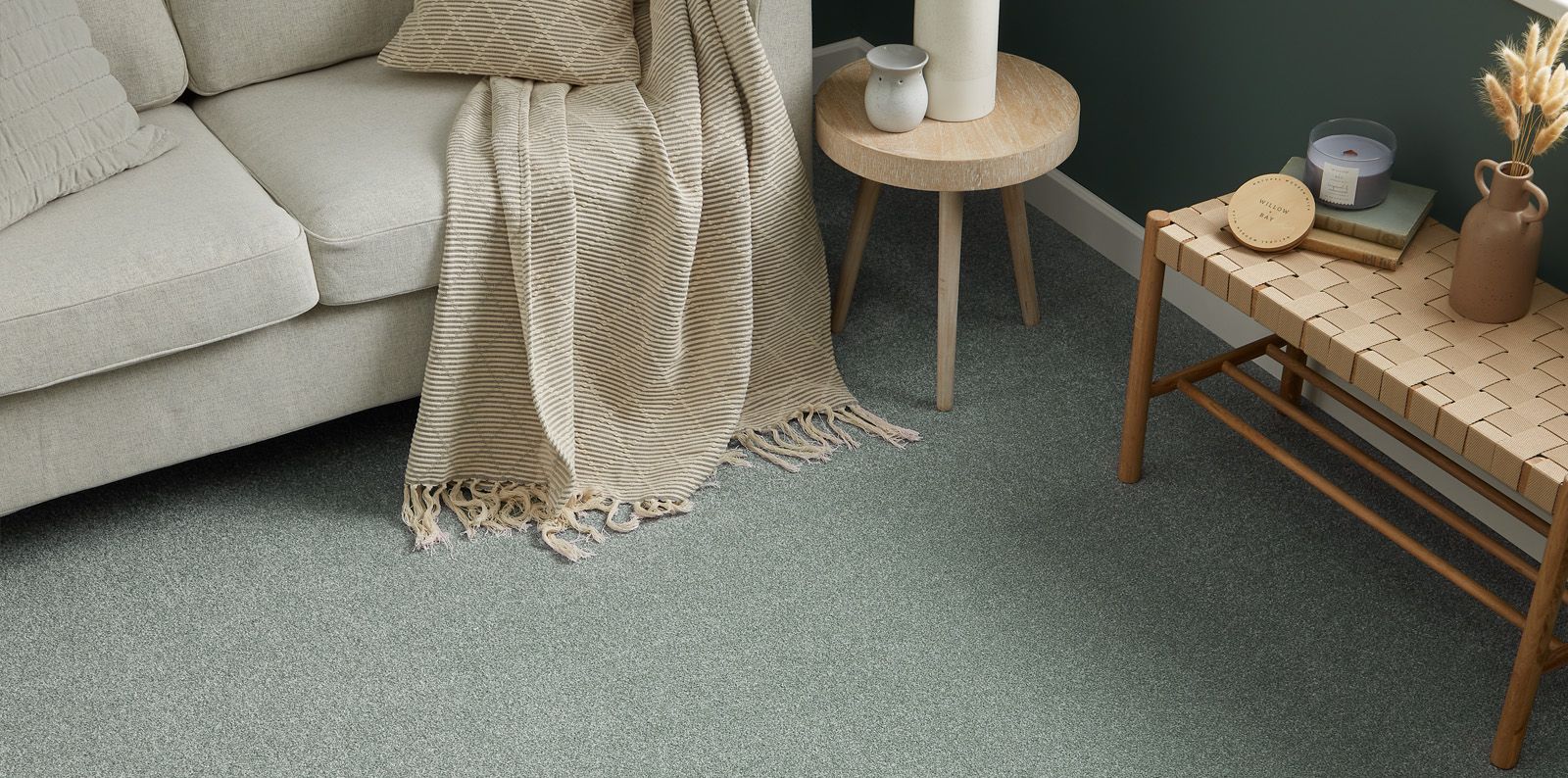 Soft green carpet in a living room with a cream sofa and neutral accessories
